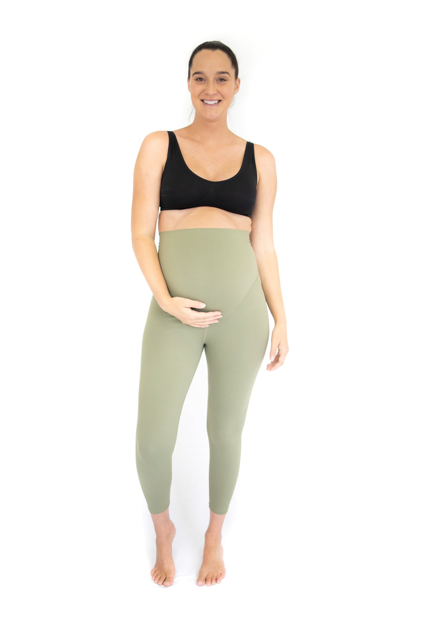 Pregnant woman in black sports bra and olive Emamaco maternity leggings