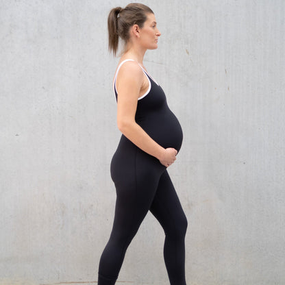 Pregnant woman in black athletic clothing showcasing Emama Maternity Bodysuit designed for comfort