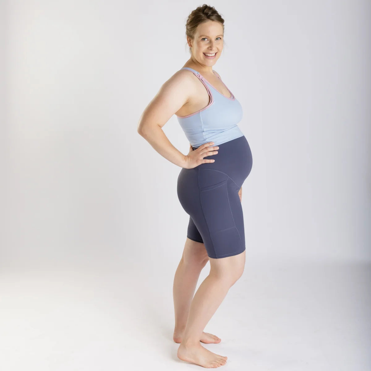 Pregnant woman in Emama Shorts, light blue tank top, navy shorts, final sale offer