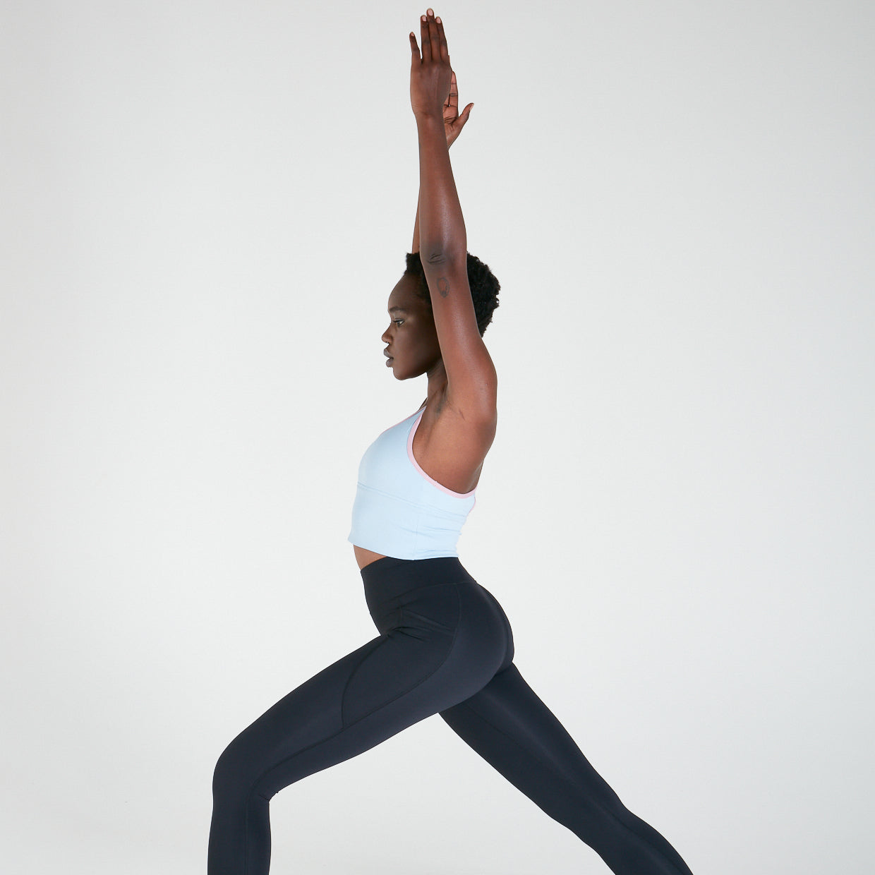 Woman in yoga pose wearing Long Line Crop Top - Powder Blue for maximum support