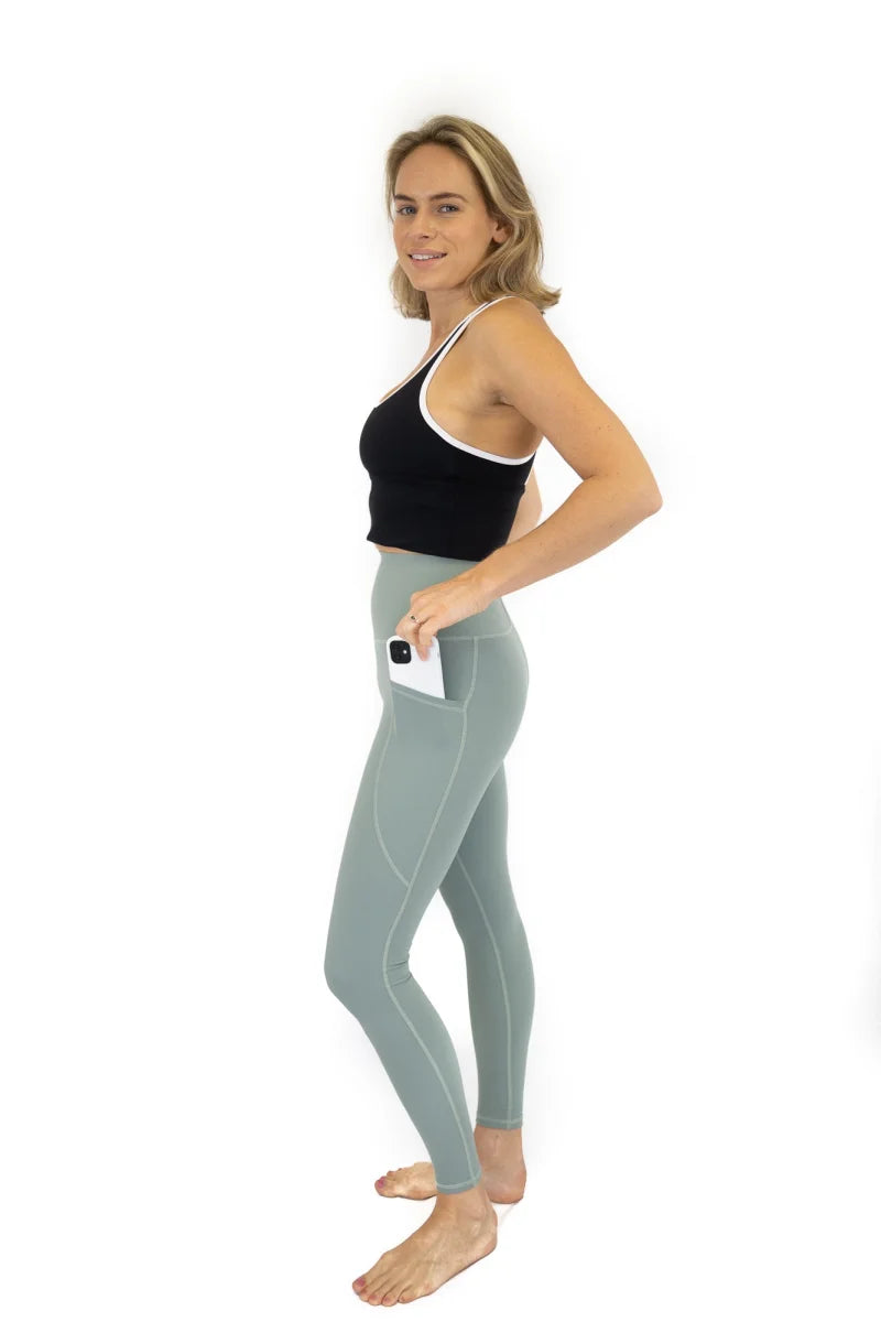 Woman in black tank top and blue leggings showcasing Shaper Move Leggings on final sale