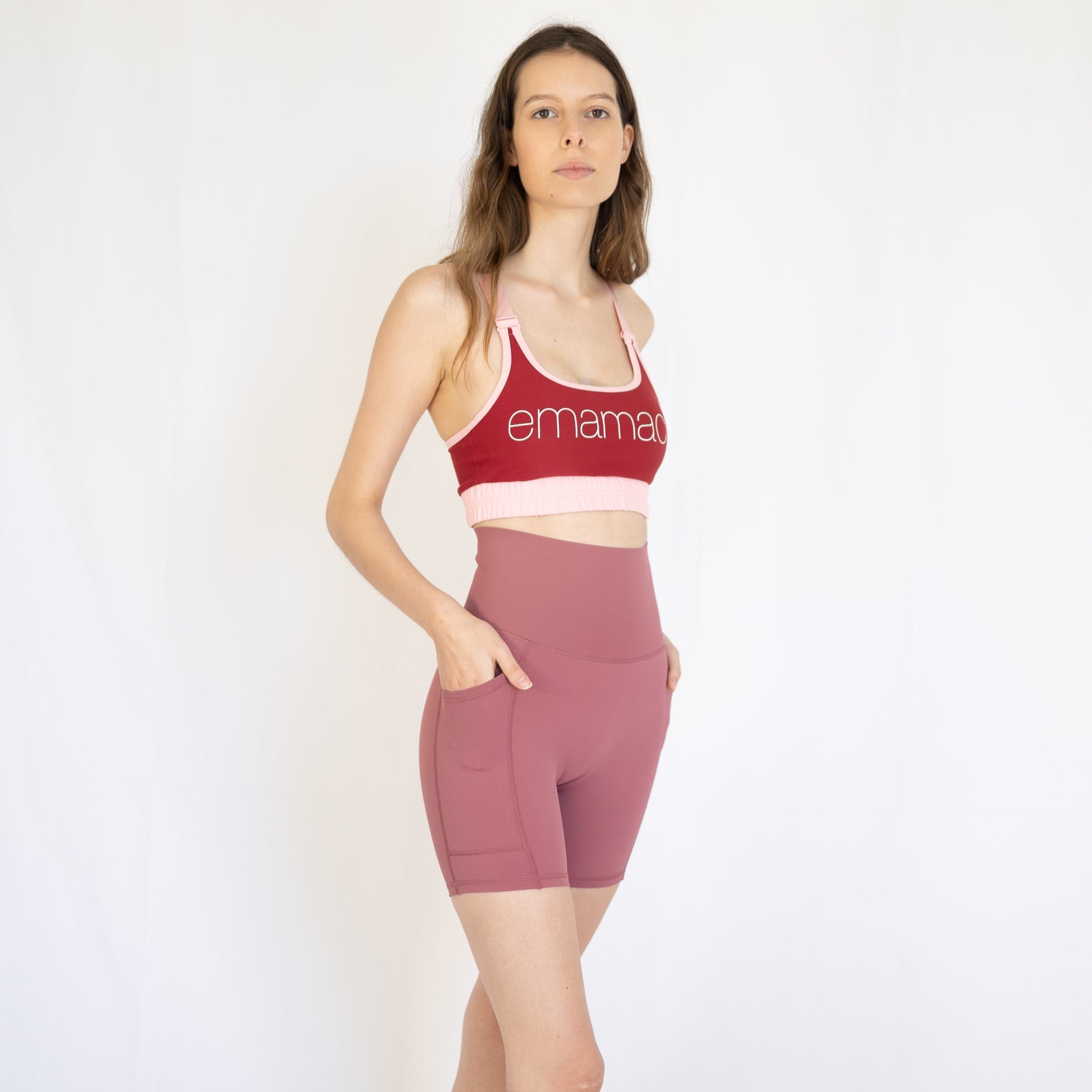 Woman in red sports bra and pink high-waisted shorts showcasing Shaper Move activewear