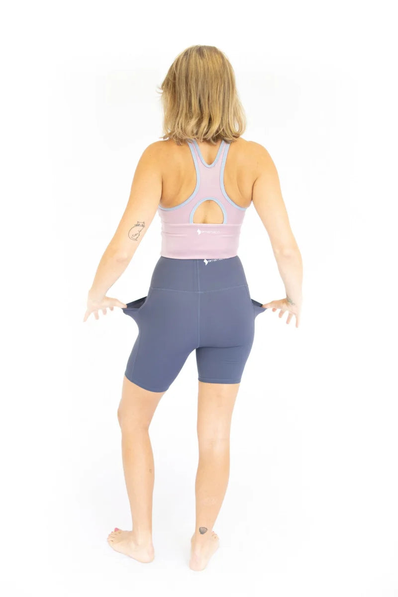 Woman in high waist Shaper Move Shorts with pockets, showing off stylish workout attire