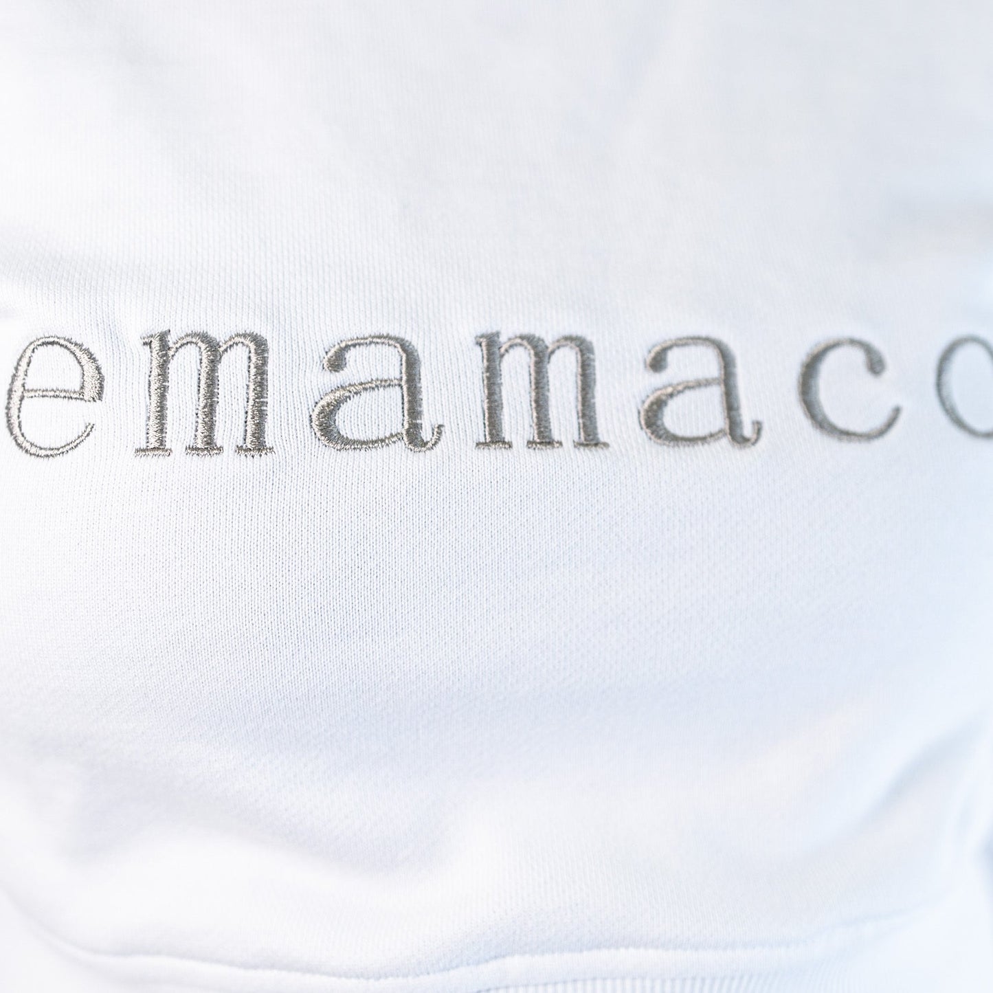 Delicately stitched emamaco logo on a light-colored Snow High Neck Jumper