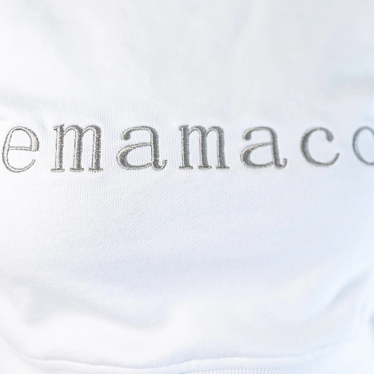 Delicately stitched emamaco logo on a light-colored Snow High Neck Jumper