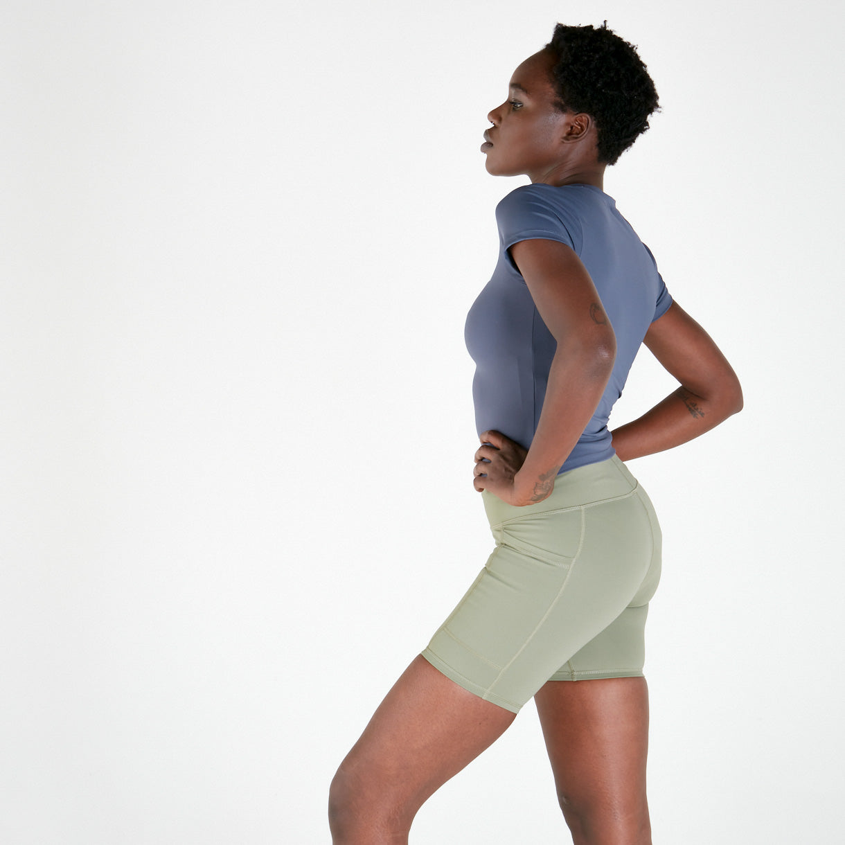 Woman in blue T-shirt and green shorts showcases TSHIRT - TWILIGHT in supaflex material