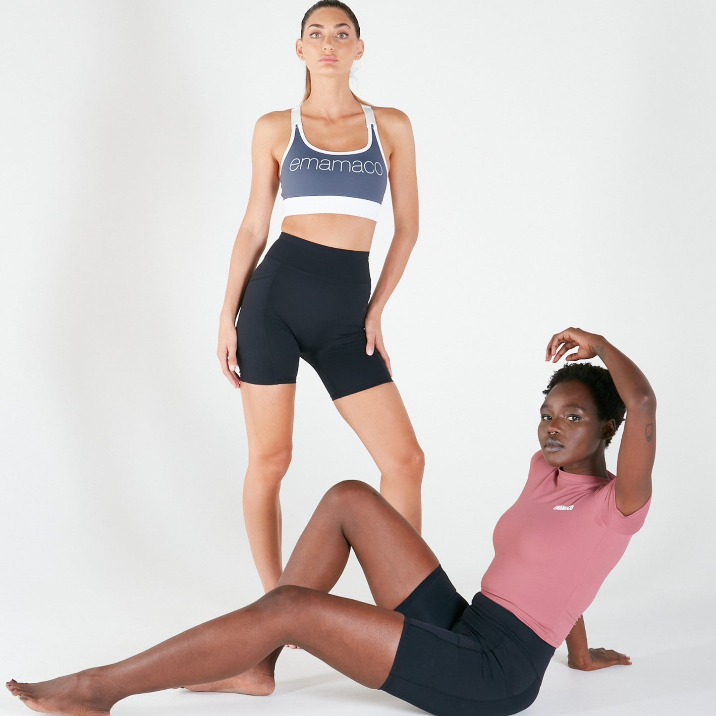 Two women in athletic wear showcasing Vibe Shorts with pockets and regular fit waistband