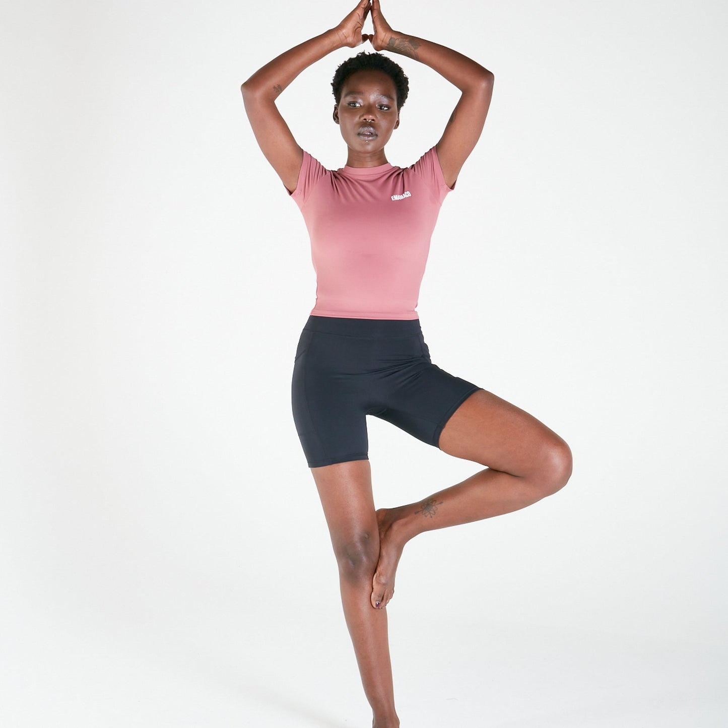 Woman in yoga tree pose wearing Vibe Shorts with regular fit waistband in black